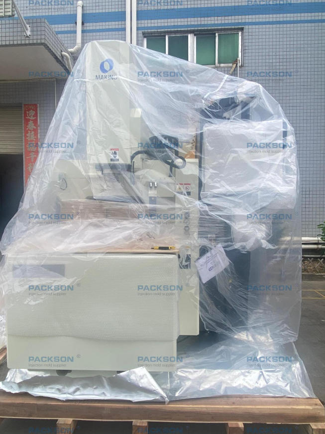 A front-facing view of a new Makino EDM machine under protective plastic wrapping, ready for use at the Packson injection mold supplier facility to enhance precision tooling. A front-facing view of a new Makino EDM machine under protective plastic wrapping, ready for use at the Packson injection mold supplier facility to enhance precision tooling.